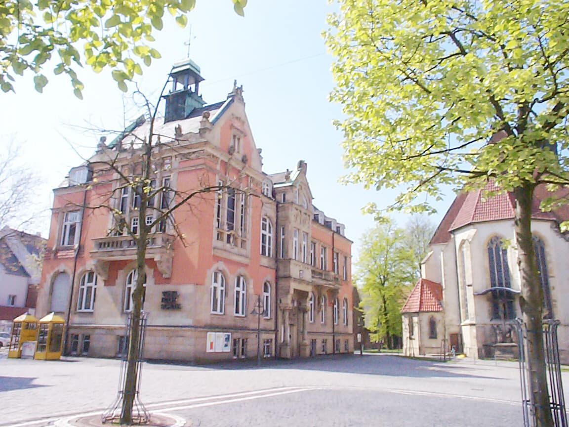 Historisches Rathaus von Ahlen, eingerahmt von grünen Bäumen